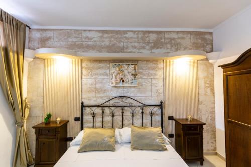 a bedroom with a large bed and two night stands at Pompei Luxury Rooms in Pompei