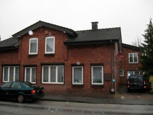ceglany dom z samochodem zaparkowanym przed nim w obiekcie Ferienwohnung Ditz I w mieście Büdelsdorf
