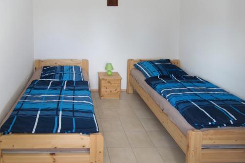 two twin beds in a bedroom with a night stand at Ferienwohnung Brodda Kerntopp in Bisdorf