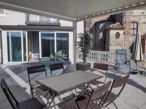 Une table et des chaises en bois sont disponibles sur la terrasse. dans l'établissement La magia delle Langhe appartamenti con vista, à Novello