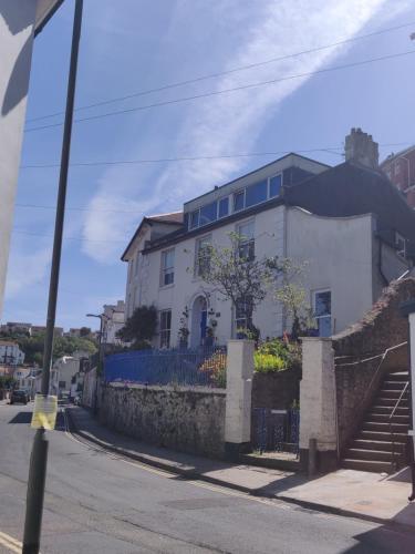 a white house on the side of a street at Luxury dog friendly home in Brixham harbour with sea views and free parking in Brixham