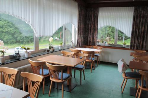 a dining room with tables and chairs and windows at Hotel Restaurant Neu-Holland in Kassel