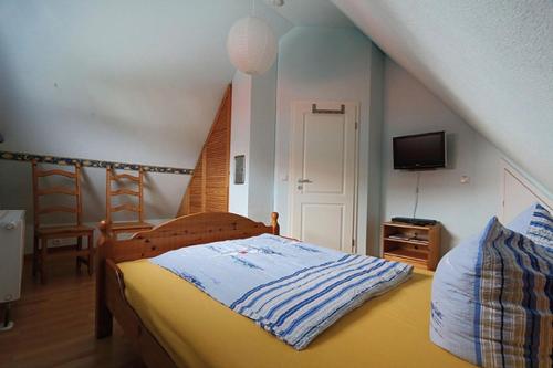 a bedroom with a bed and a tv and a staircase at Uns Muschelhus in Zingst