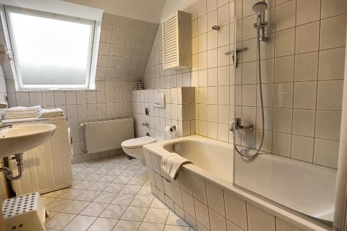 a bathroom with a tub and a toilet and a sink at Ostseewelle Whg 3 in Zingst