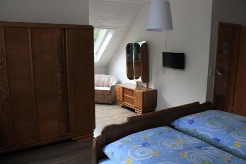 a bedroom with a bed and a dresser and a tv at Hotel Restaurant Neu-Holland in Kassel