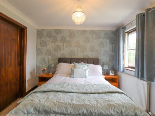 a bedroom with a bed and a chandelier at 1 The Gardens in Stowmarket