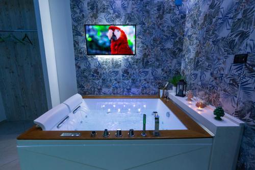 a bathroom with a tub with a bird on the wall at Pompei Luxury Rooms in Pompei
