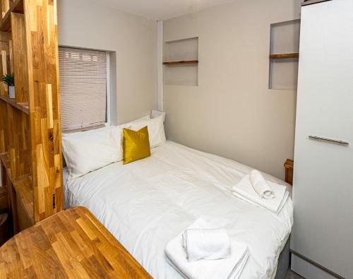 Un pequeño dormitorio con una cama blanca y una mesa en Entire Luxury Studio in the Central of Reading en Reading