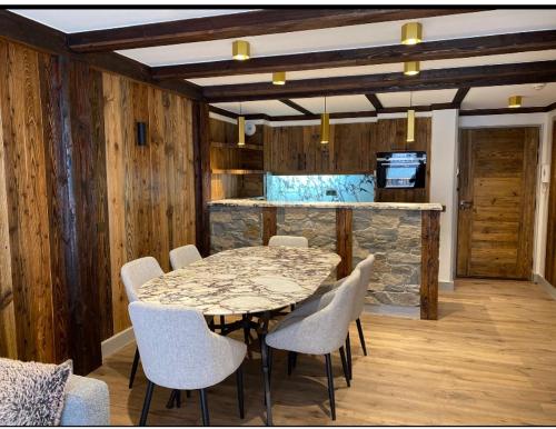 a dining room with a marble table and chairs at Luxury suite 70m2 balcon courchevel1850 parking in Courchevel