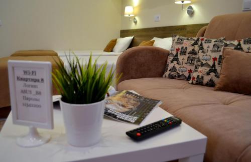 a living room with a couch and a table with a plant at Апартаменты Park & House 8 рядом с источником и парком in Essentuki