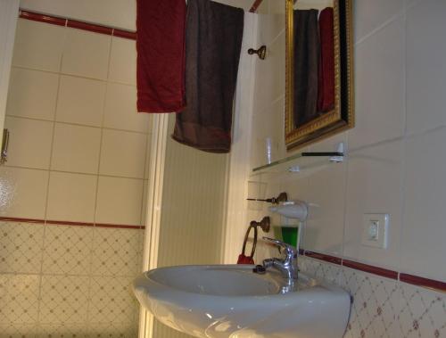 ein Badezimmer mit einem weißen Waschbecken und einer Dusche in der Unterkunft Apartment im englischen Stil mit Meerblick in Icod de los Vinos