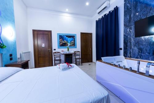 a bedroom with a white bed and a tv at Pompei Luxury Rooms in Pompei