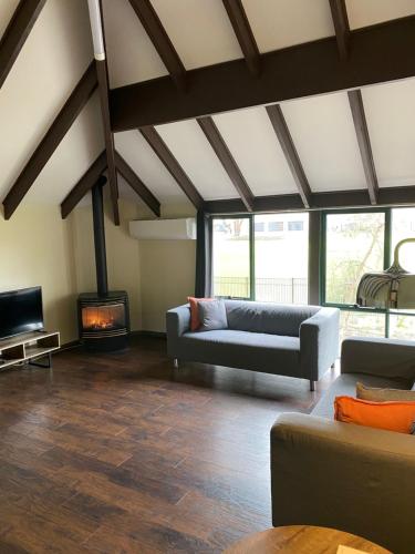 Una sala de estar con un sofá y una chimenea. en Hahndorf Motel, en Hahndorf