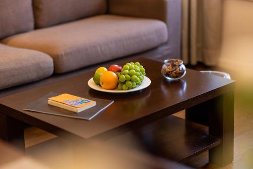 a plate of fruit on a coffee table in a living room at Starr Hotel Shanghai (Shanghai Railway Station) in Shanghai