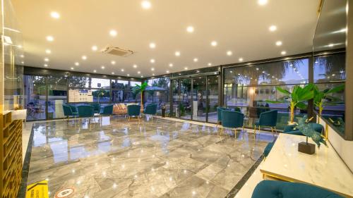a lobby with chairs and tables and windows at Leaf Port Hotel in Antalya