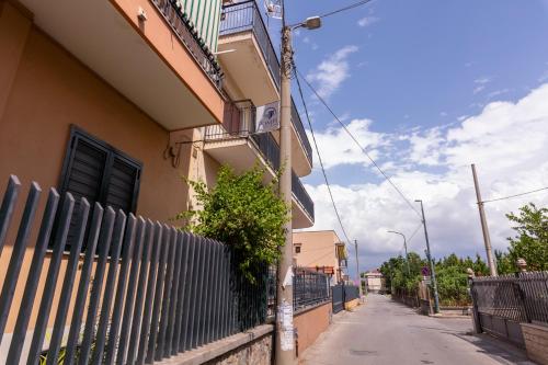 a fence on the side of a building next to a street at Pompei Luxury Rooms in Pompei