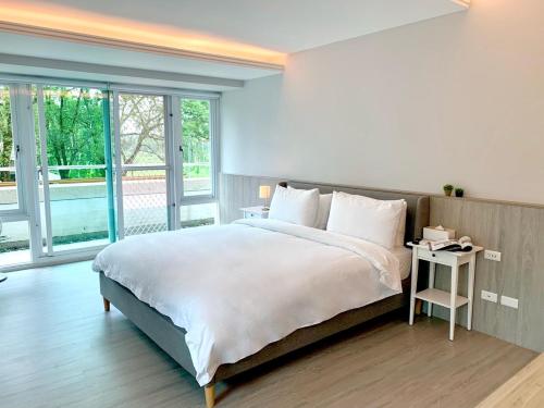 a bedroom with a large white bed with a side table at Revel Villa in Puli