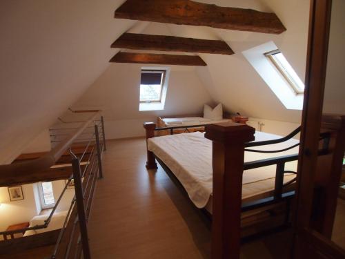 a attic room with bunk beds and a staircase at Gut Rattelvitz, Galerie F in Gingst