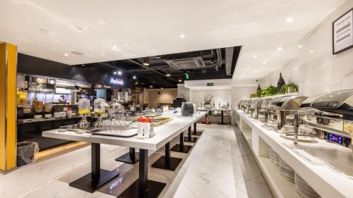 a restaurant with a long counter with dishes at Starr Hotel Shanghai (Shanghai Railway Station) in Shanghai
