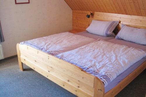 a large wooden bed in a room with a wooden wall at Ferienhof Ralf Becker Nr4 in Dänschendorf