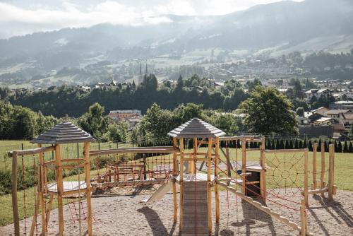 a playground in a park with mountains in the background at Appartements Wieshof in Sankt Johann im Pongau