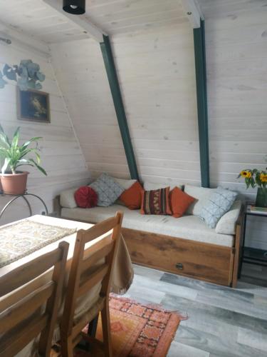 a couch in the corner of a room with a table at Aframe Shanti DreamDim in Svityazʼ
