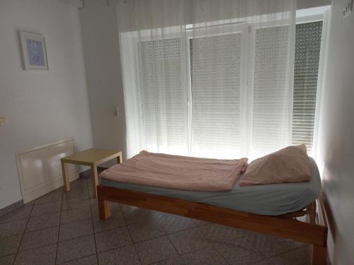 a bed sitting in a room with a window at Muskat in Hanhofen