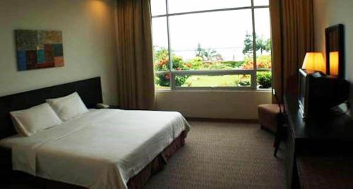 a hotel room with a bed and a window at Straits View Hotel JB in Johor Bahru