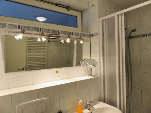 a bathroom with a sink and a mirror at Lindenstraße 43, Whg 1 - Nord bei Nordost in Zingst