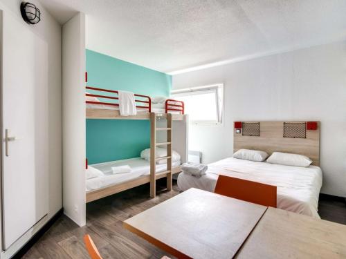 ブールジュにあるHotelF1 Bourges Le Subdrayの二段ベッド2台とテーブルが備わる客室です。