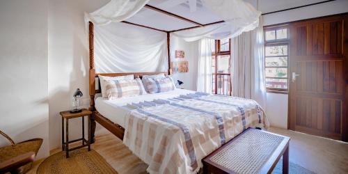 una camera con letto a baldacchino di Jua House a Lamu