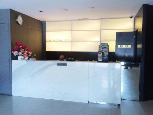a lobby with a counter with a person sitting at it at Straits View Hotel JB in Johor Bahru