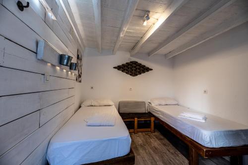 2 camas en una habitación pequeña con pared en Amaka House en Granada