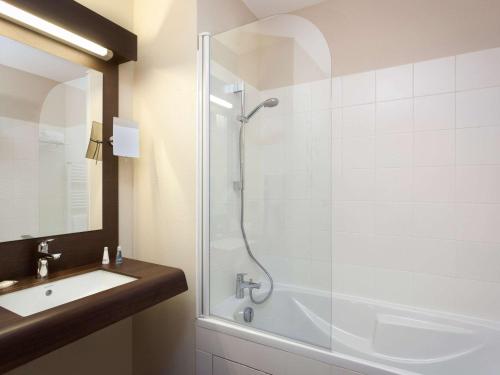 y baño con ducha y lavamanos. en Aparthotel Adagio Lyon Patio Confluence en Lyon