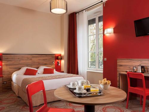 Cette chambre d'hôtel comprend un lit et une table avec un plateau/bouilloire. dans l'établissement Aparthotel Adagio Lyon Patio Confluence, à Lyon