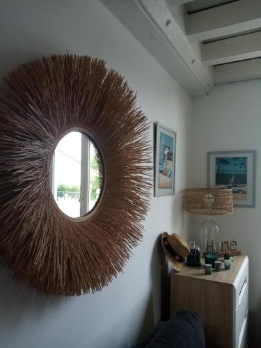 un miroir rond sur le mur d'une pièce dans l'établissement Sucrée et Douceur, à Cabourg