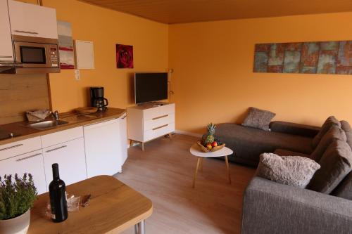 un soggiorno con divano e una cucina di Appartement am Mühlenberg a Waren