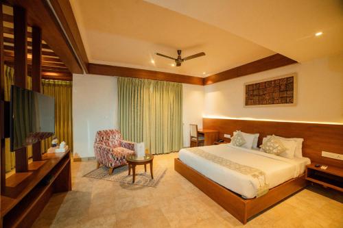 um quarto de hotel com uma cama e uma televisão em The Ramvilas - A Rooftop Pichola Lake View Hotel em Udaipur