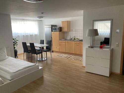 a room with a bed and a kitchen with a table at By Stelwag in Bermatingen