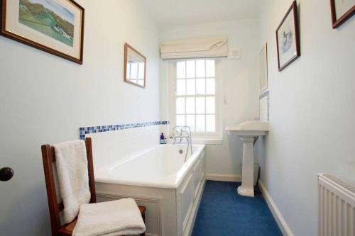 La salle de bains blanche est pourvue d'une baignoire et d'un lavabo. dans l'établissement Hall Cottage, Wighill near York and Leeds, à Tadcaster