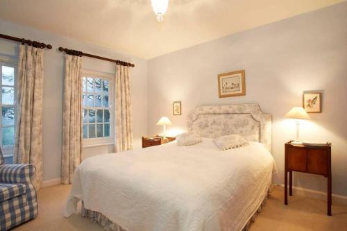 a bedroom with a white bed and a window at Hall Cottage, Wighill near York and Leeds in Tadcaster