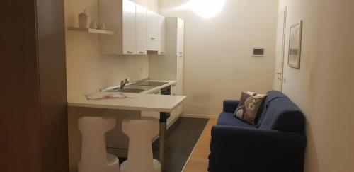 una cucina con lavandino e divano blu di Rio Central M3 Sondrio e Stazione Centrale a Milano