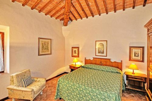een slaapkamer met een bed en een stoel bij Agriturismo Fattoria Il Piano - Appartamento Lavanda - San Gimignano in Borgatello