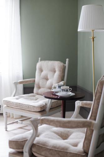 a room with two chairs and a table and a lamp at Krepelin Apartments in Kristiinankaupunki