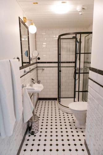 a bathroom with a shower and a sink and a toilet at Krepelin Apartments in Kristiinankaupunki