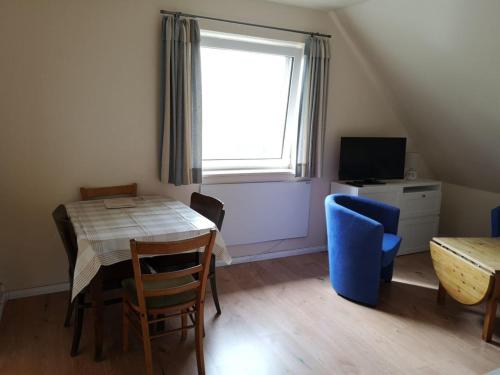 a dining room with a table and chairs and a window at zum Wels in Wester-Ohrstedt