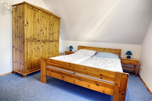 a bedroom with a wooden bed and a wooden cabinet at Waldesruh - App2 in Zingst
