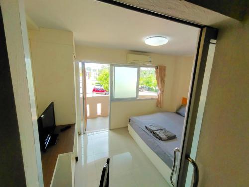 um pequeno quarto com uma cama e uma janela em โรงแรมวิจิตรพร อุบล VJP Hotel Ubon em Ubon Ratchathani
