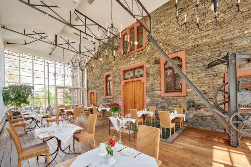 a restaurant with tables and chairs and a brick wall at Weinromantikhotel Richtershof in Mülheim an der Mosel