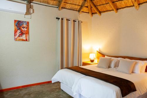 Bongan Safari Lodge في Mbabat: غرفة نوم بسرير كبير في غرفة
